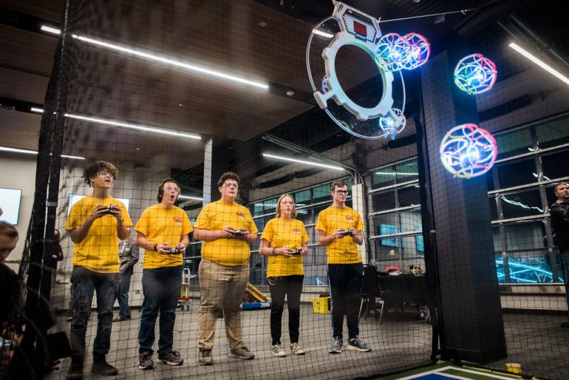 a team tries to score points by remote controlling their drones toward a target goal.