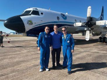 Three hurricane researchers in front of a plane