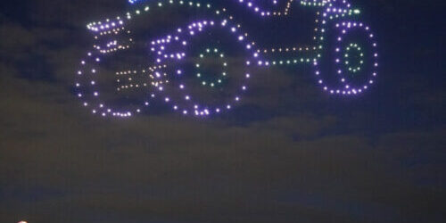 Illuminated drones light up night sky in the form of a car.