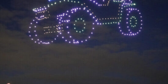 Illuminated drones light up night sky in the form of a car.