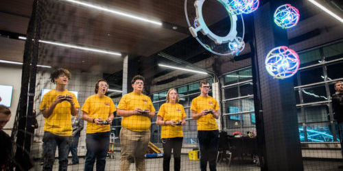 a team tries to score points by remote controlling their drones toward a target goal.